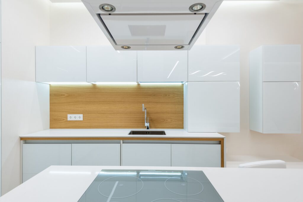 Bright spotless modern kitchen with white cabinets and wood accents