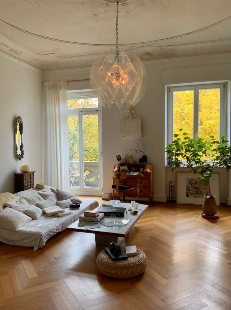 Clean cozy living room with warm autumn light and fall foliage outside