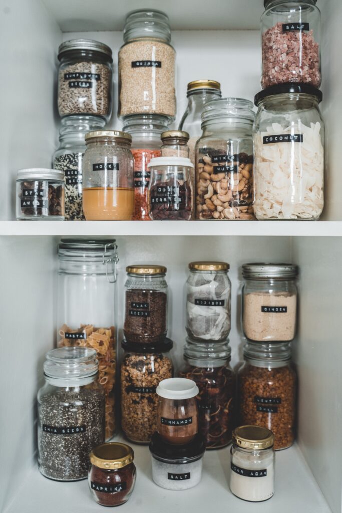 Neatly organized pantry shelves with labeled glass jars